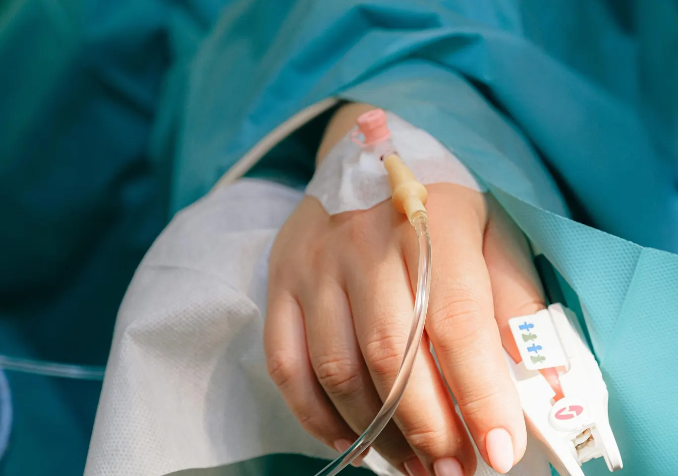 Detoks alkoholowy Krotoszyn: dłoń z wenflonem i pulsoksymetrem pod nadzorem